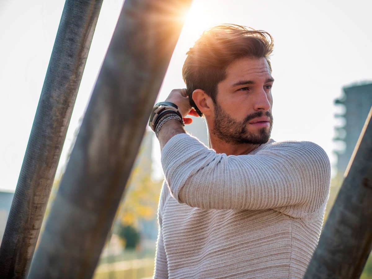 Man with a full head of hair and beard outdoors
