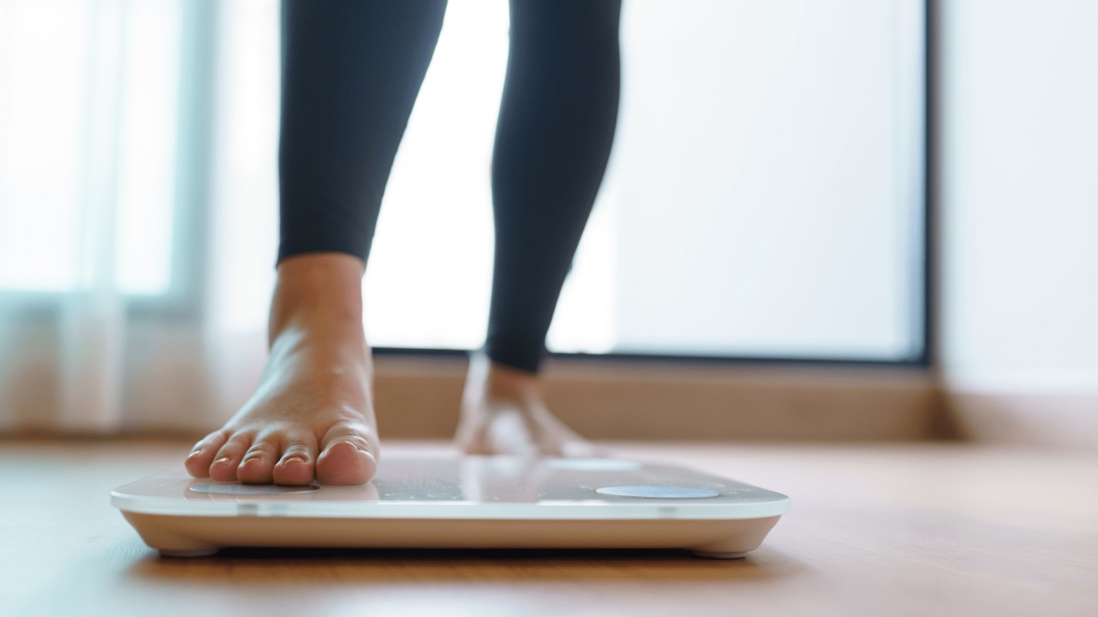 Person stepping onto a body-composition scale
